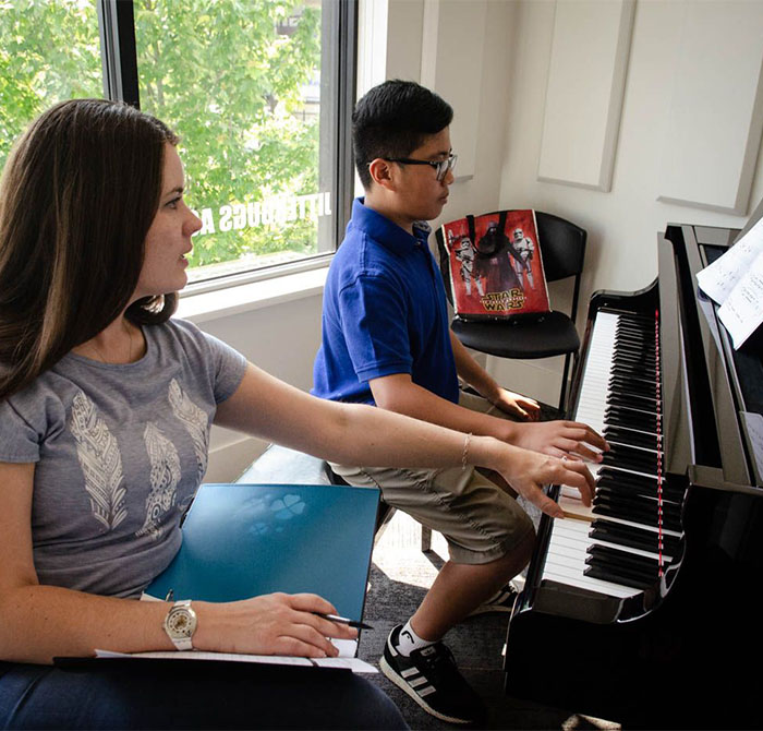 teacher helping student at piano