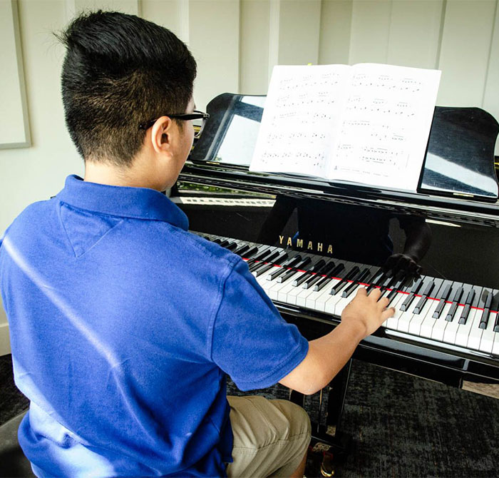boy in blue shirt playing piano