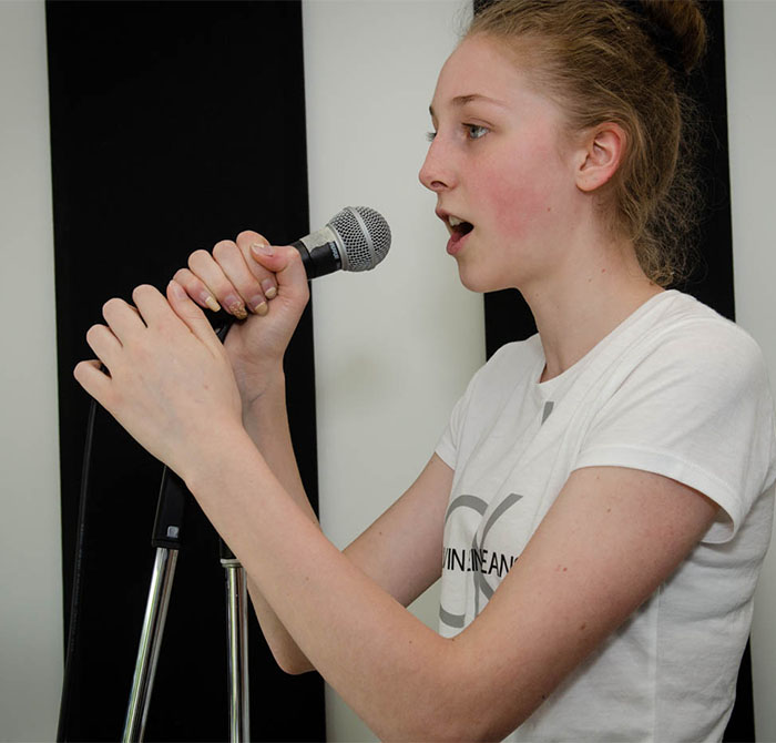 girl in white T at the microphone