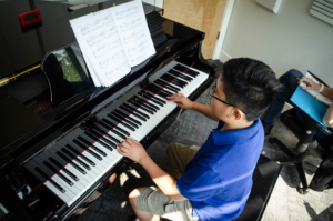 Young boy working on his piano lesson