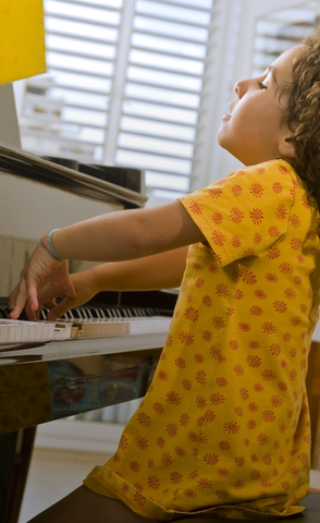 kid in yellow shirt playing piano