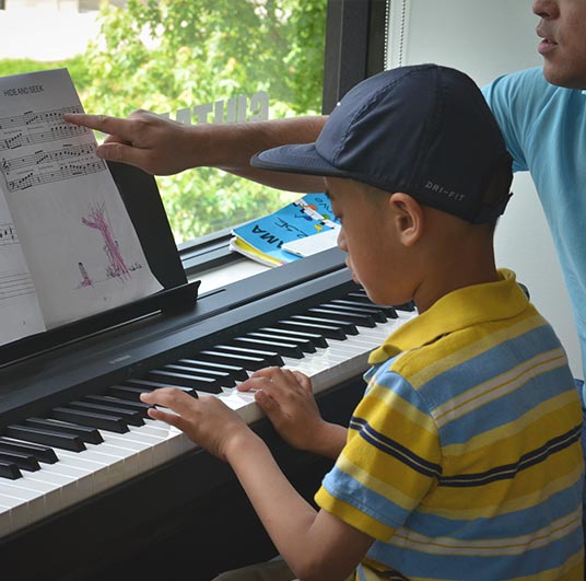boy in hat learning piano