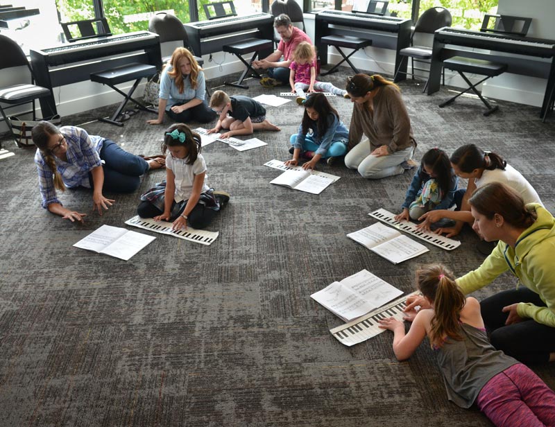 kids studying piano on the ground