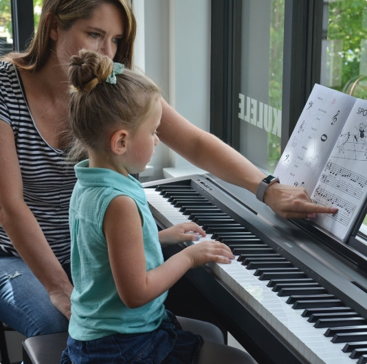 teacher with young student at piano